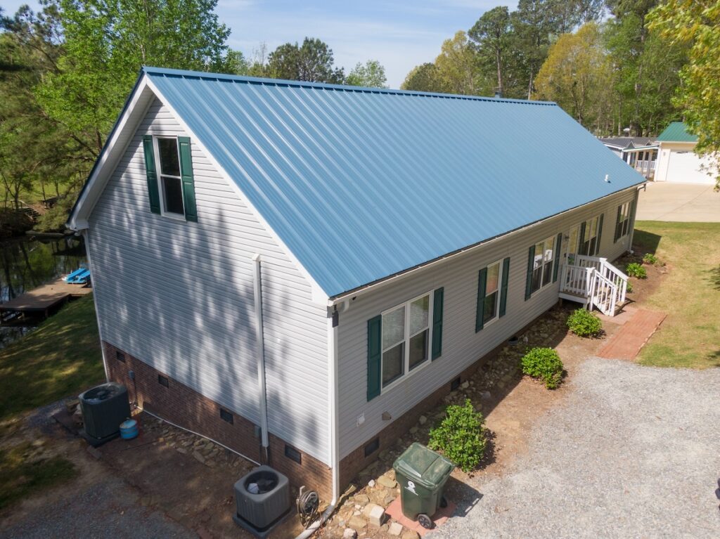 New steel metal light blue roof on a single family home featuring 5V style panels.