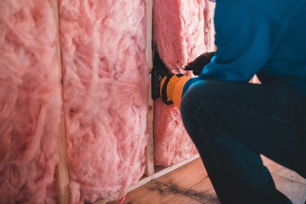 person installing insulation in a house
