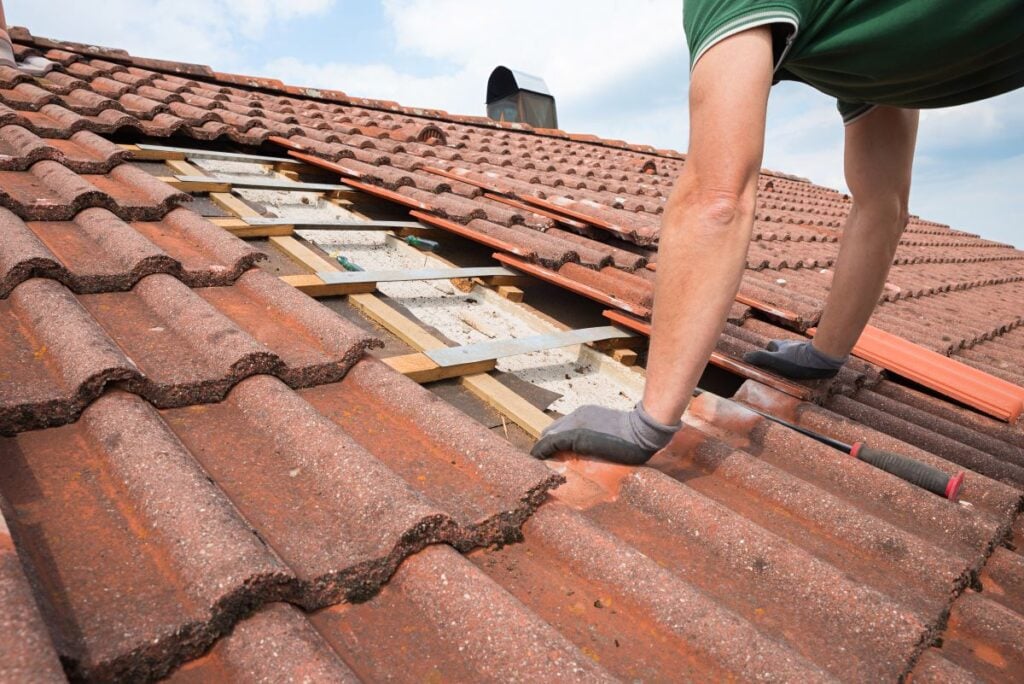 person repairing tile roof