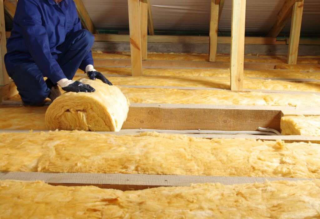 best attic insulation worker using gloves to unroll wool