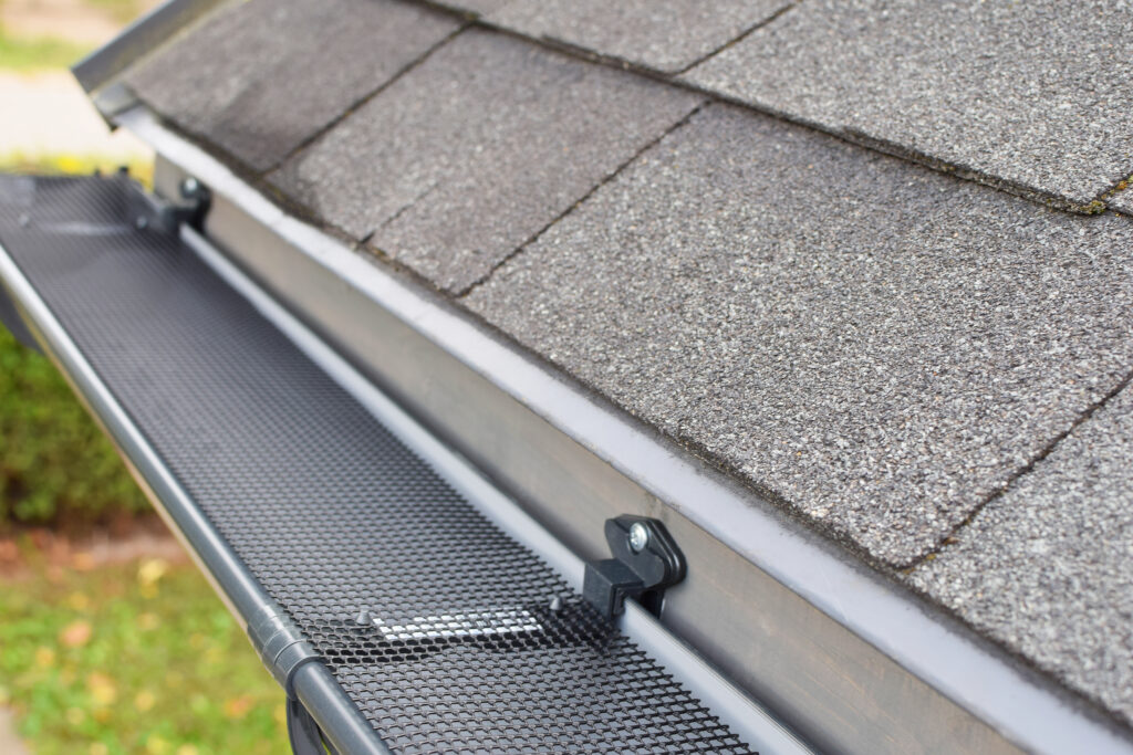 Plastic guard over new dark grey plastic rain gutter