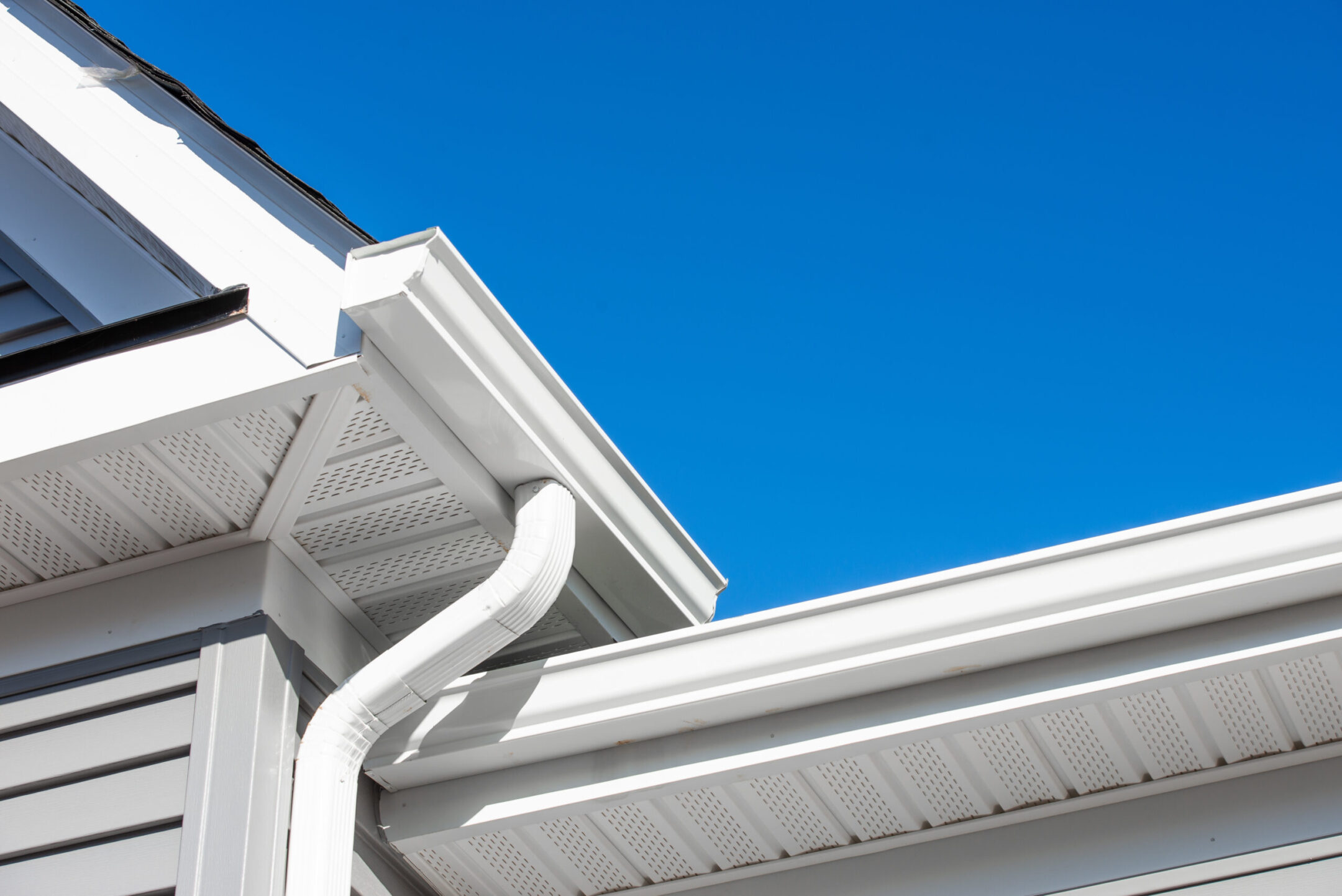 Colonial white gutter guard system, soffit providing ventilation to the attic