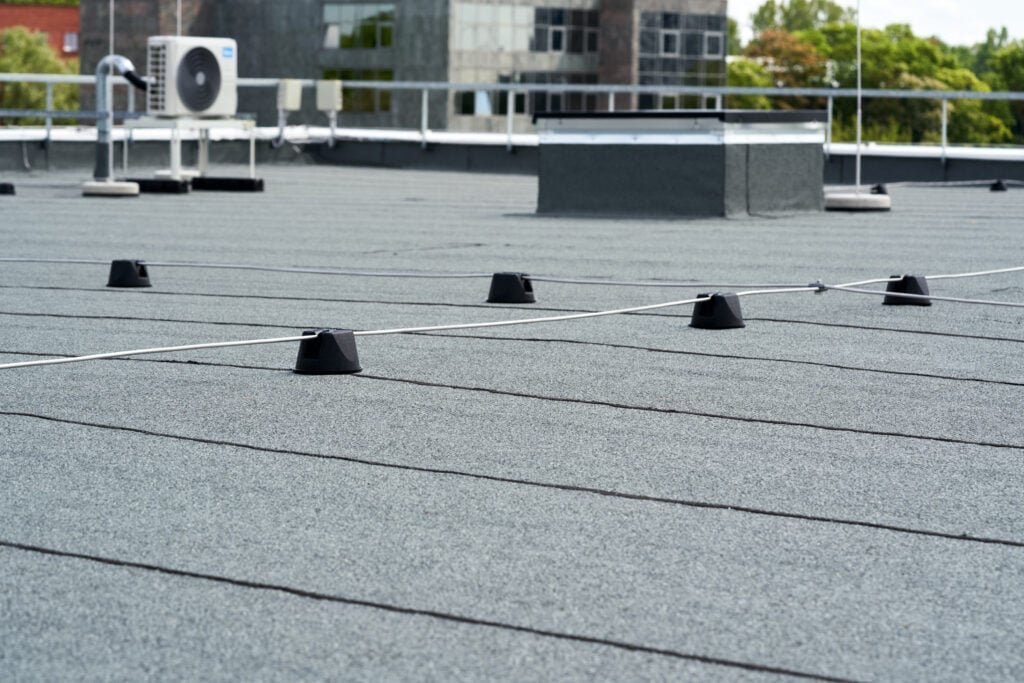 Flat roof covered with bitumen membrane for waterproofing.