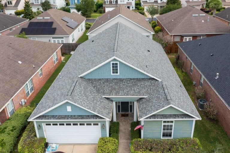 Large teal house with a light grey shingle roof