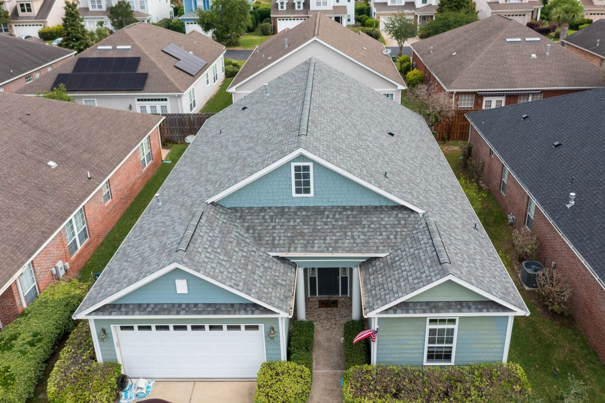 Large teal house with a light grey shingle roof