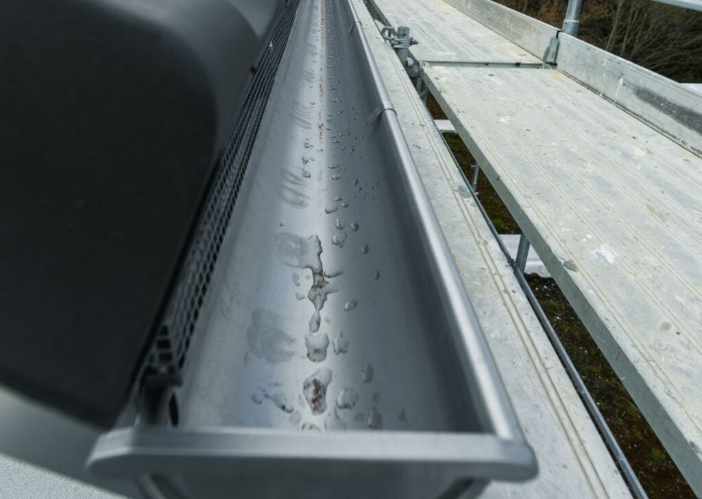 a clean seamless gutter with a gutter guard installed to improve water flow and debris protection