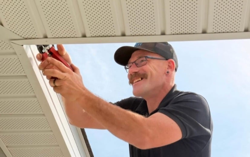Quality Roofing Solutions' Gutter Technician Repairing a gutter