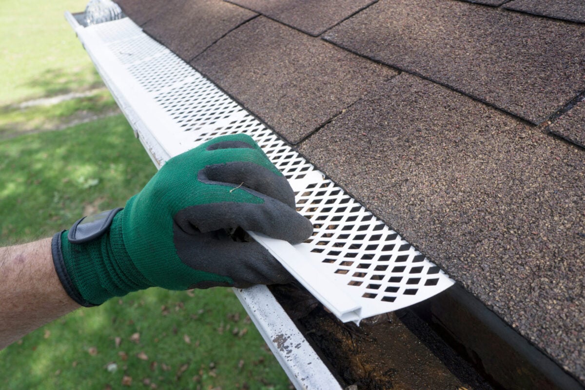 gutter guard installation Contractor adjusting plastic gutter guards to get them to fit.