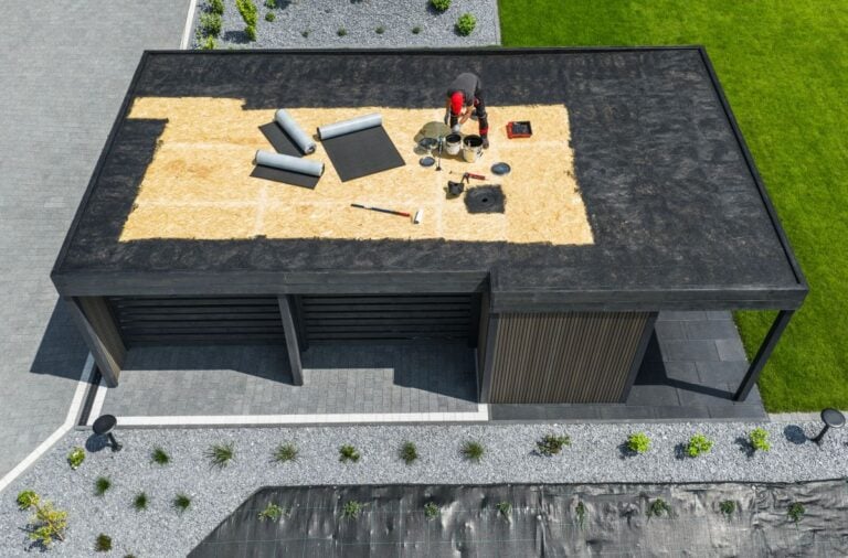 guy applying EDPM membrane on flat roof roof waterproofing services
